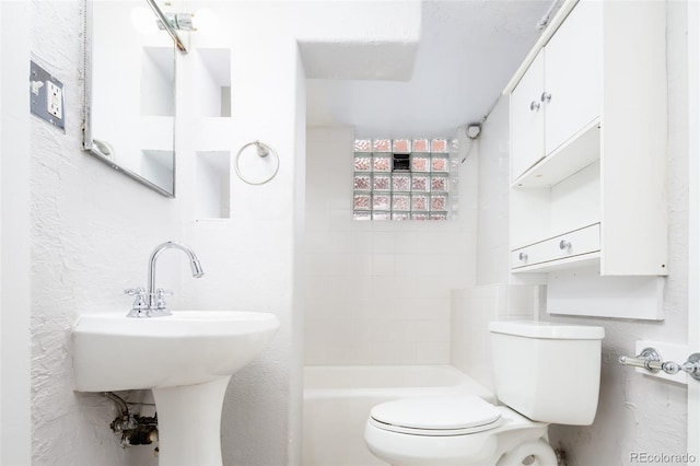 bathroom featuring a textured wall and toilet