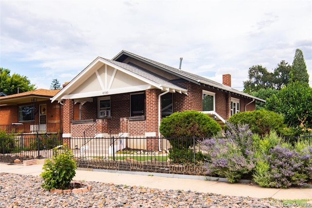 view of front of home featuring brick siding, a chimney, and a fenced front yard