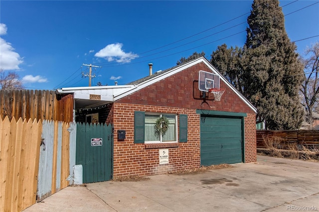 exterior space with concrete driveway, brick siding, and fence