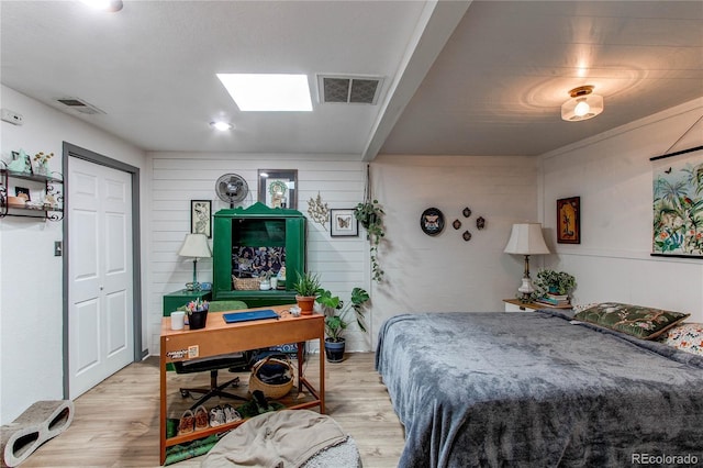 bedroom with a skylight, visible vents, and light wood-style floors