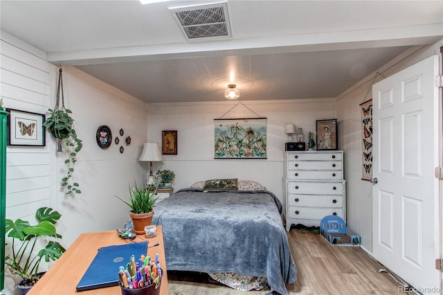 bedroom with visible vents and wood finished floors