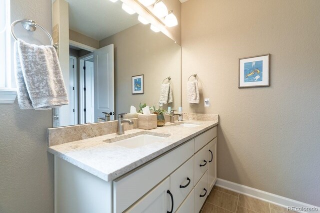 565 Pikes View Dr, Erie, CO 80516 - full bath with double vanity, tile patterned flooring, and baseboards