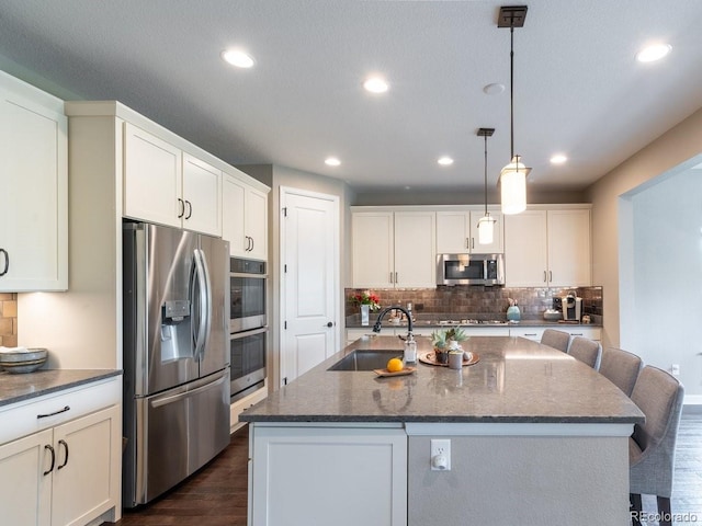 565 Pikes View Dr, Erie, CO 80516 - kitchen featuring stainless steel appliances, a sink, decorative backsplash, recessed lighting, and dark wood finished floors