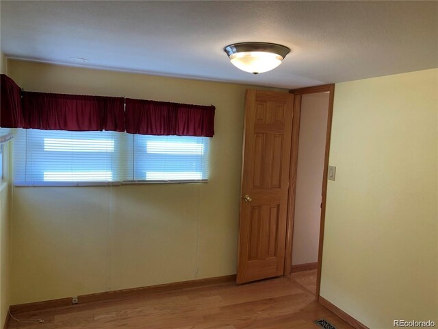 empty room featuring plenty of natural light and light hardwood / wood-style flooring