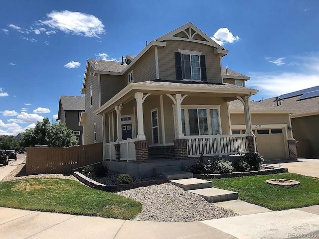 view of front of home with a garage, covered porch, and a front yard