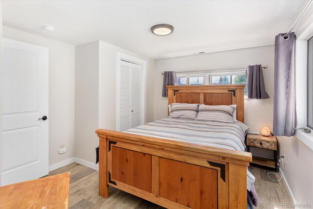 bedroom featuring a closet, baseboards, and wood finished floors