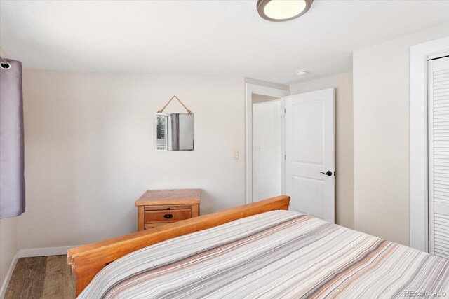 bedroom featuring a closet, baseboards, and wood finished floors