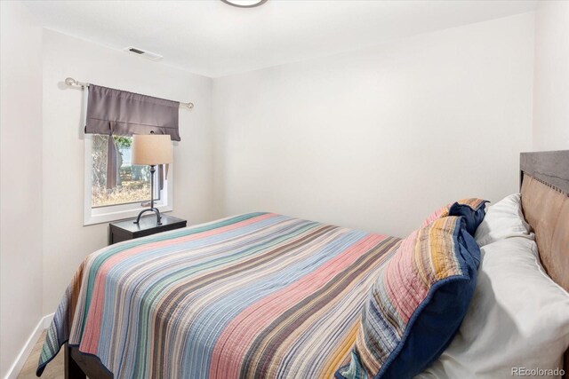 carpeted bedroom featuring visible vents