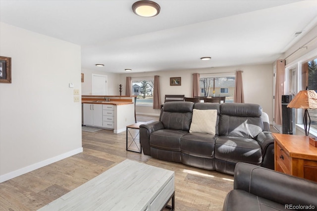 living area featuring light wood-type flooring and baseboards