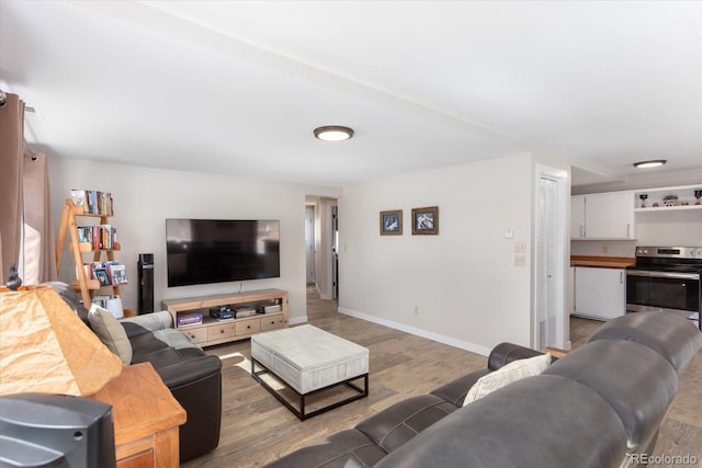 living area featuring light wood-style flooring and baseboards