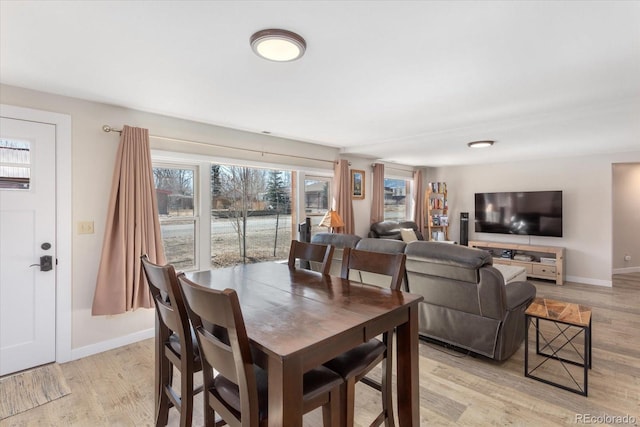 dining area with baseboards and light wood-style floors