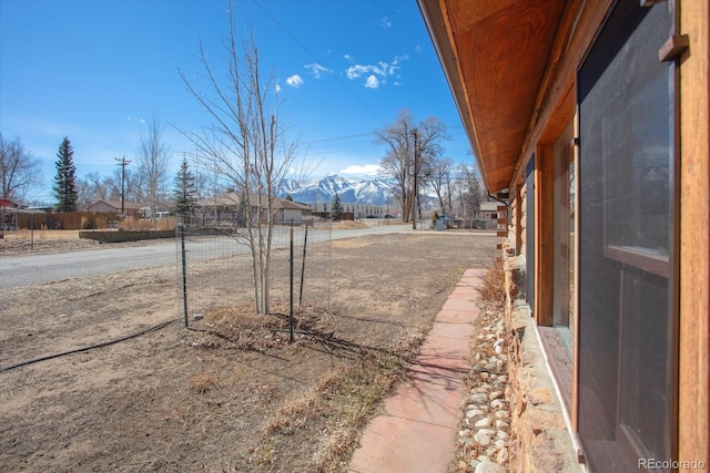 view of yard featuring fence and a mountain view