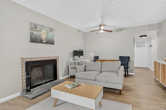 14934 E Hampden Cir Unit 3, Aurora, CO 80014 - living room featuring light wood-style floors, a ceiling fan, and a fireplace