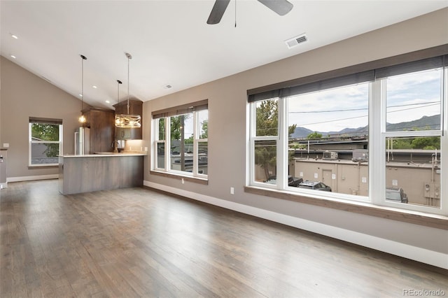 unfurnished living room featuring ceiling fan, dark hardwood / wood-style flooring, and vaulted ceiling