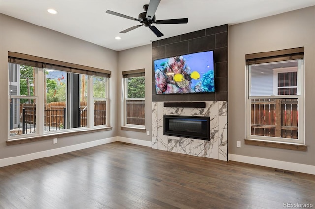 unfurnished living room with dark wood-type flooring, a fireplace, and ceiling fan