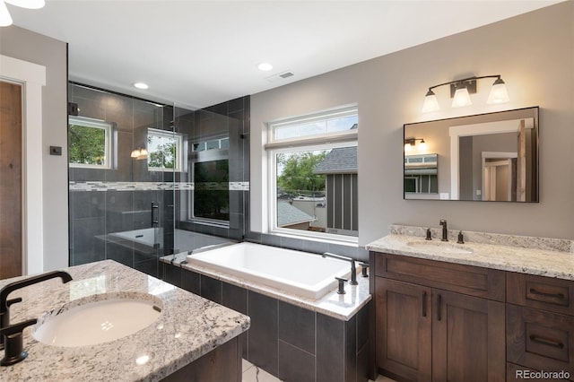 bathroom featuring vanity, a wealth of natural light, and independent shower and bath