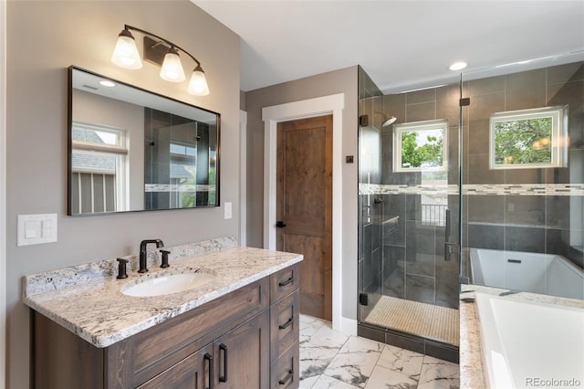 bathroom with vanity and shower with separate bathtub