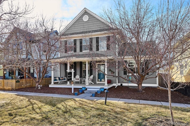 view of front of house featuring a porch, a front yard, and fence