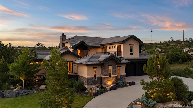1803 Avenida Del Sol, Castle Rock, CO 80104 - view of front of property with stone siding, a balcony, stucco siding, concrete driveway, and a chimney