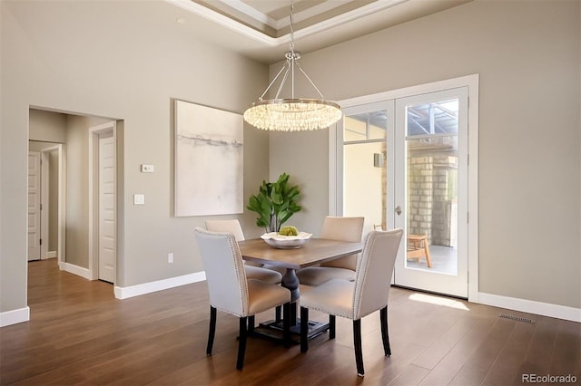 1803 Avenida Del Sol, Castle Rock, CO 80104 - dining space with dark wood finished floors, a chandelier, ornamental molding, french doors, and a tray ceiling