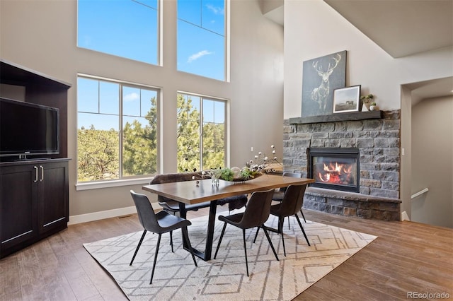 1803 Avenida Del Sol, Castle Rock, CO 80104 - dining area with a fireplace, a towering ceiling, and light wood-style floors