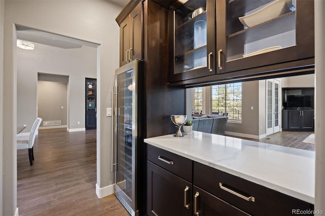 1803 Avenida Del Sol, Castle Rock, CO 80104 - kitchen featuring beverage cooler, glass insert cabinets, wood finished floors, and dark brown cabinets