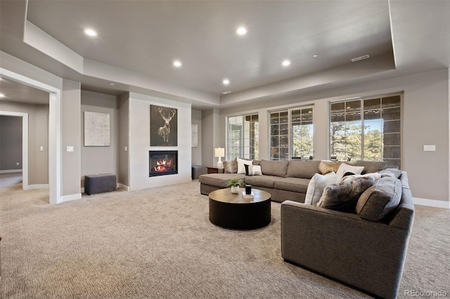 1803 Avenida Del Sol, Castle Rock, CO 80104 - living room featuring light colored carpet, a raised ceiling, recessed lighting, a glass covered fireplace, and plenty of natural light