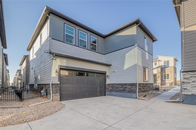 23931 E 40th Ave, Aurora, CO 80019 - view of home's exterior featuring a garage, stone siding, and driveway
