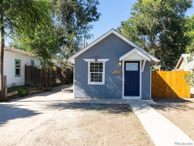 view of front facade with fence and stucco siding