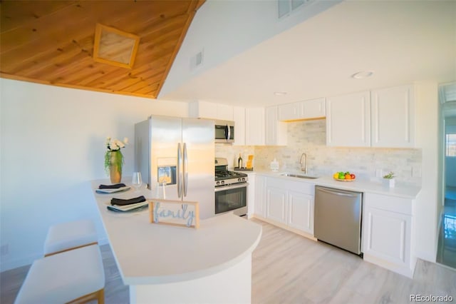 kitchen featuring visible vents, tasteful backsplash, a sink, stainless steel appliances, and white cabinetry