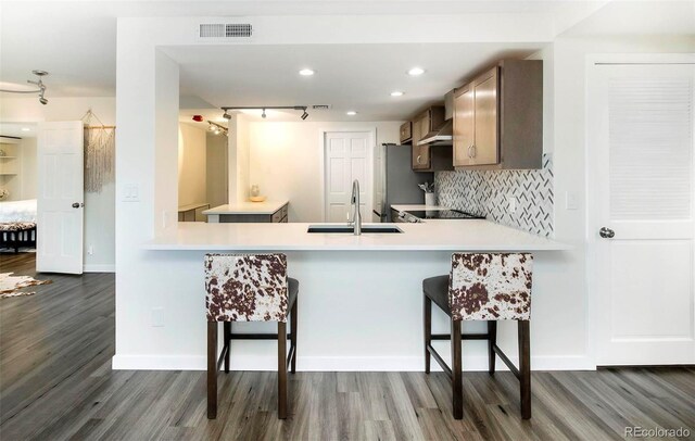 800 Pearl St Unit 1010, Denver, CO 80203 - kitchen with dark wood-style floors, backsplash, freestanding refrigerator, and a peninsula