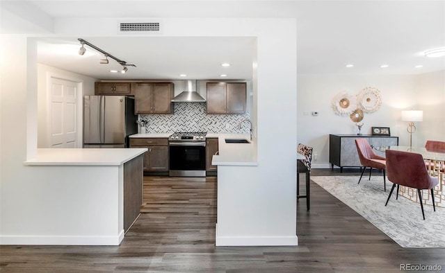 800 Pearl St Unit 1010, Denver, CO 80203 - kitchen with appliances with stainless steel finishes, wall chimney range hood, light countertops, tasteful backsplash, and rail lighting
