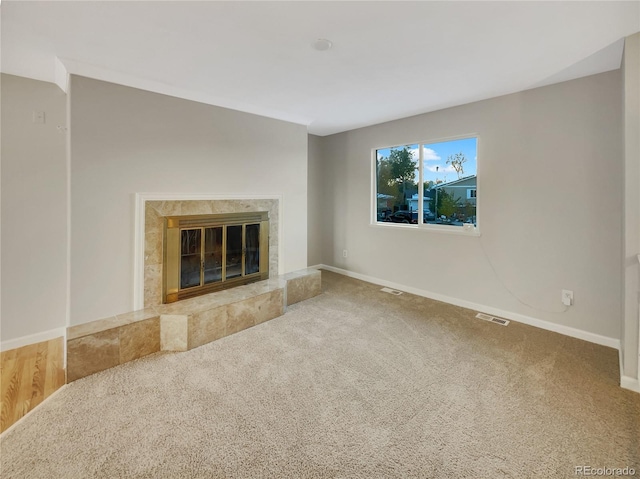 unfurnished living room with carpet and a tile fireplace