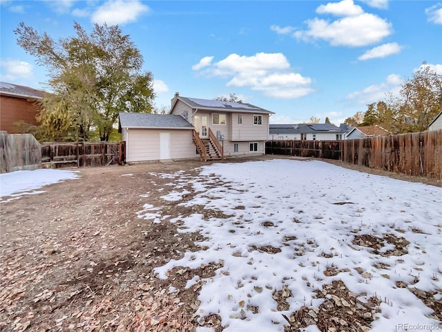 view of snow covered back of property