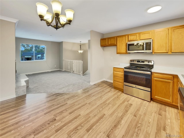 kitchen featuring decorative light fixtures, light hardwood / wood-style floors, appliances with stainless steel finishes, and an inviting chandelier