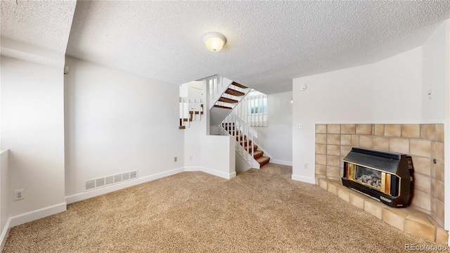 3732 Rosewalk Ct, Highlands Ranch, CO 80129 - unfurnished living room with heating unit, stairs, carpet flooring, a textured ceiling, and a tiled fireplace