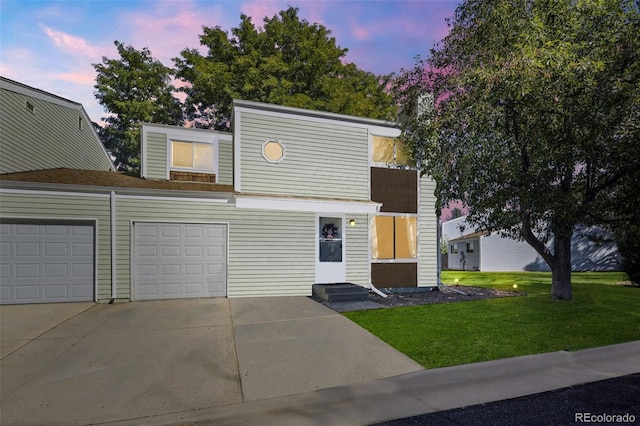 view of front of property featuring entry steps, driveway, an attached garage, and a front lawn