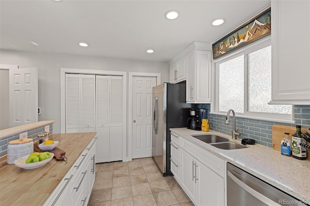 kitchen featuring recessed lighting, a sink, white cabinets, appliances with stainless steel finishes, and backsplash