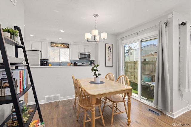 dining area featuring a chandelier, visible vents, and a wealth of natural light