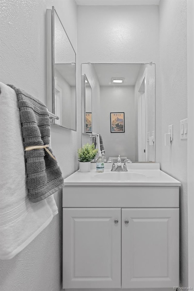 bathroom featuring vanity and a textured wall