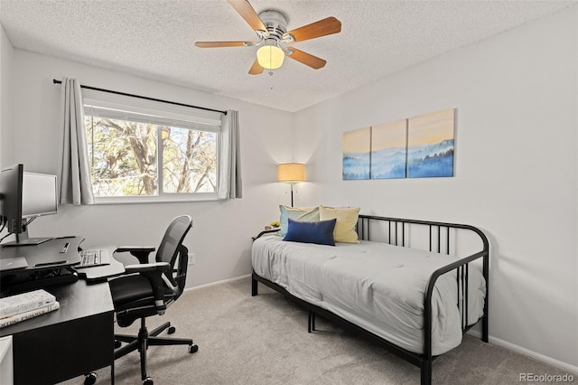 carpeted bedroom with a textured ceiling, baseboards, and a ceiling fan