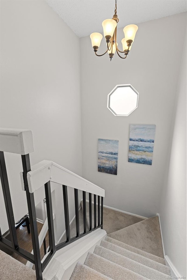 stairway featuring baseboards, an inviting chandelier, and carpet flooring