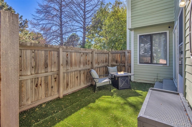 view of yard featuring a fenced backyard and a fire pit