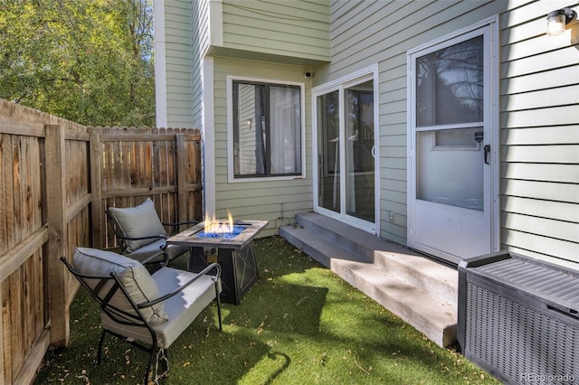 view of patio with entry steps, fence, and a fire pit