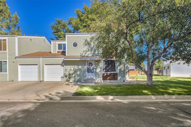 view of property featuring a front yard, concrete driveway, and an attached garage