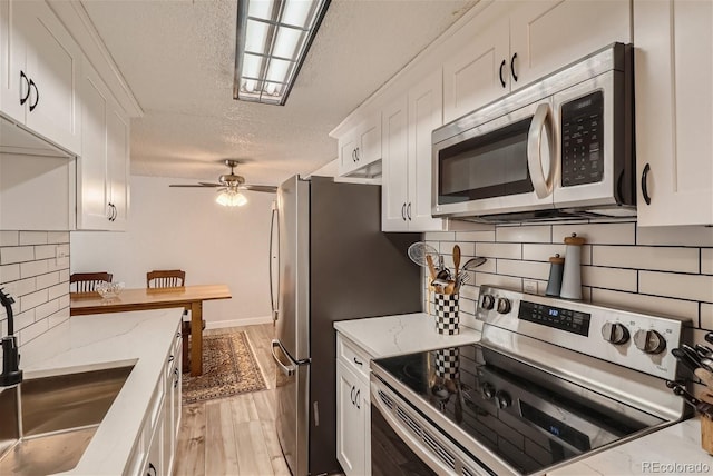 kitchen featuring light hardwood / wood-style flooring, white cabinets, sink, and stainless steel appliances