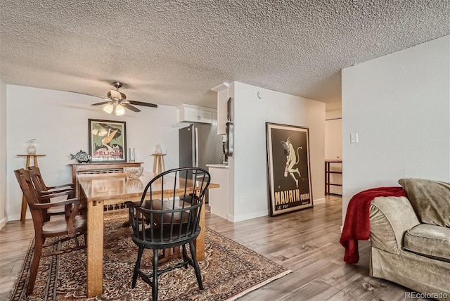 dining area with hardwood / wood-style floors, a textured ceiling, and ceiling fan