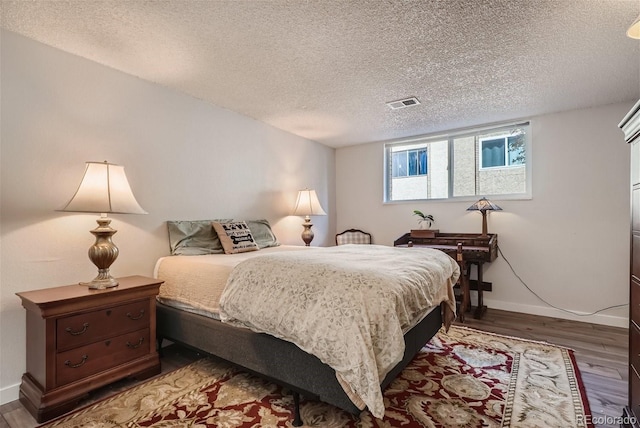 bedroom featuring wood-type flooring and a textured ceiling