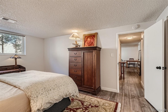 bedroom featuring wood-type flooring and a textured ceiling