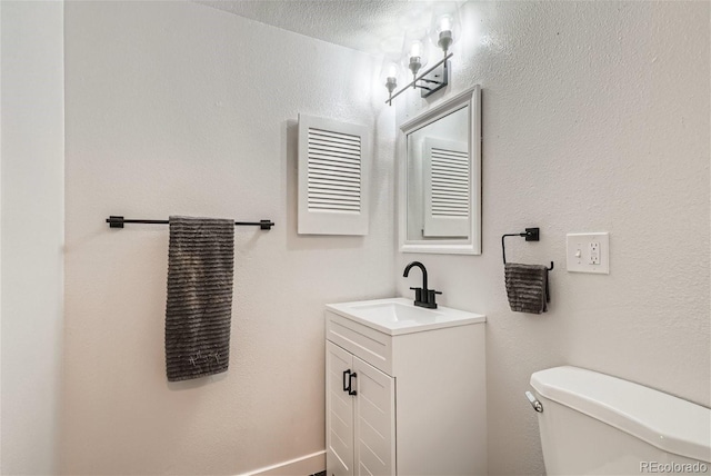 bathroom with vanity, a textured ceiling, and toilet